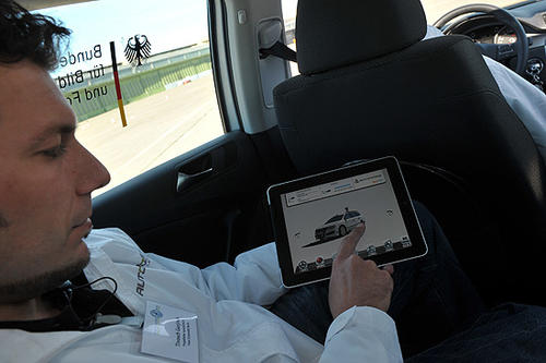 Projektleiter Tinosch Ganjneh erklärt wie mittels mobiler Geräte, wie z. B. einem iPad, sich sämtliche Sensoren im Auto ablesen lassen und Befehle für das Fahrzeug übertragen werden.