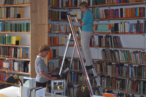 Die Bibliothekarinnen Renate Arnsberg-Busch (auf der Leiter) und Monika Schröder bei der Bestandsrevision.