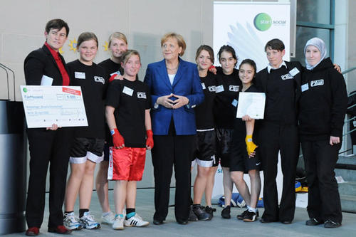 Bundeskanzlerin Dr. Angela Merkel überreichte den Preis an „Boxgirls“-Gründerin Heather Cameron (1.v.l.) und Trainerin sowie Koordinatorin Sarah Bitterling (2.v.r.), Berlins einzige Ringrichterin, und ihre Schützlinge