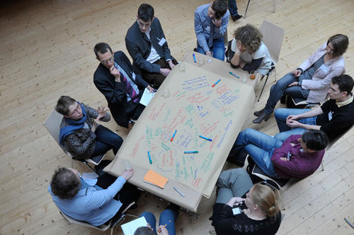 An einem Tisch: Nachwuchswissenschaftlerinnen und -wissenschaftler verschiedener Disziplinen beim Austausch während der Ideenwerkstatt der Dahlem Research School.