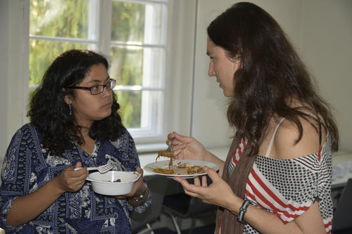Essen verbindet: Zwei Doktorandinnen beim „Pot Luck Lunch“ – einem Picknick, zu dem die Promovierenden Speisen aus ihren Heimatländern mitbringen.