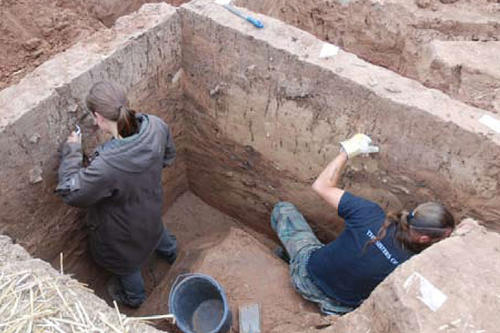 Sorgfältig werden die Profilwände einer tief eingegrabenen Abfallgrube aus der Eisenzeit für die Dokumentation präpariert.