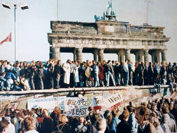 No longer fear-inspiring: A day after the border opening on November 9, 1989, the Berlin Wall at Brandenburg Gate is a popular place for both boisterous and peaceful celebrations – for East and West Berliners alike.