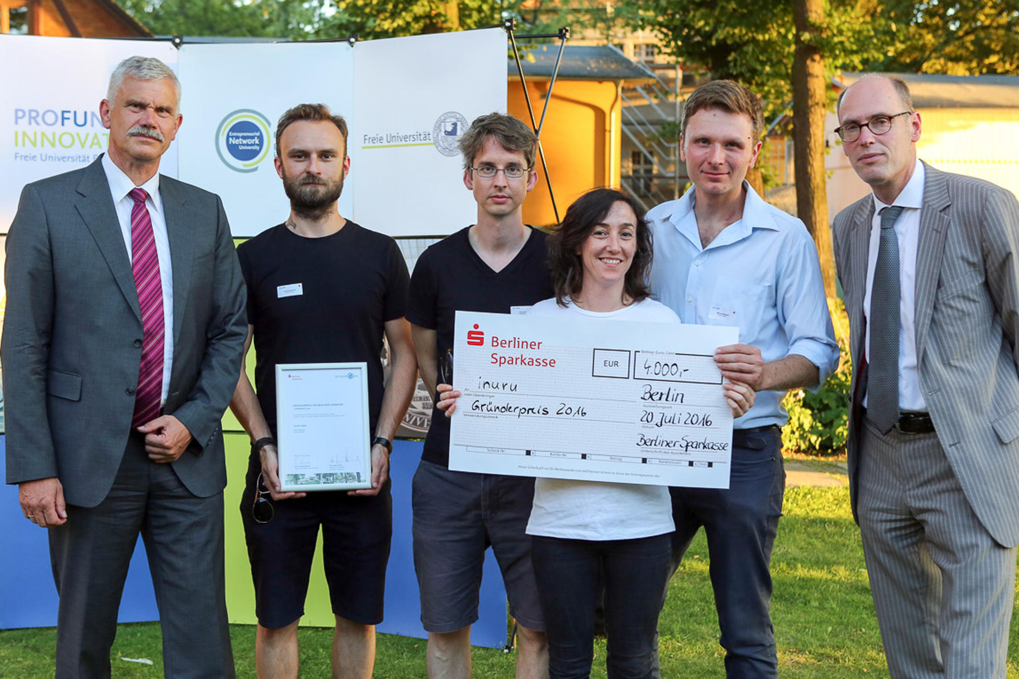Hans Jürgen Kulartz (l., Vorstandsmitglied der Berliner Sparkasse) und Universitätspräsident Prof. Dr. Peter-André Alt mit dem Gewinnerteam von INURU: Patrick Barkowski, Paul Zybarth, Alejandra Garcia und Marcin Ratajczak.