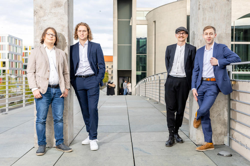 Vier Gründer von iur.crowd im Teamfoto mit Gebäuden im Hintergrund
