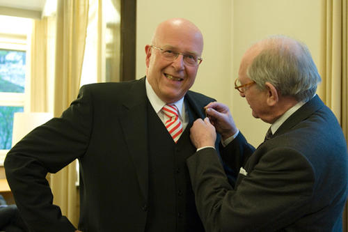 Hans-Uwe Erichsen, der Vorsitzende des Kuratoriums, steckt Dieter Lenzen die Goldene Anstecknadel der Freien Universität ans Jacket.