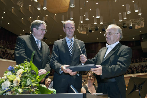 Gemeinsames Geschenk: Prof. Dr.-Ing. Jörg Steinbach, Präsident der Technischen Universität, und Prof. Dr. Peter-André Alt, Präsident der Freien Universität, überreichten Manfred Fabricius einen silbernen Dirigentenstab (v.l.n.r.).