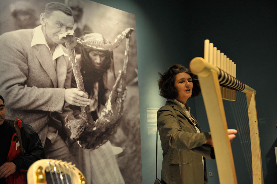 Musik war immer ein fester Bestandteil des Lebens und hatte bereits im Altertum einen hohen Stellenwert. Das Foto im Hintergrund zeigt die Ausgrabung eines Instruments, das im Vordergrund als Nachbildung zu sehen ist.