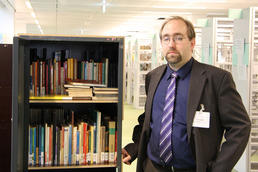 Andreas Gräff ist einer der beiden Umzugskoordinatoren, die sich um den reibungslosen Ablauf des Büchertransportes in den Neubau für die Kleinen Fächer kümmern.