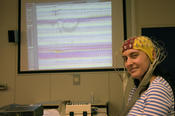 Projektion aus dem Hirn: Das EEG macht Gefühlsregungen sichtbar. Das Lächeln der jungen Frau verwandelt Linien in Wellen.