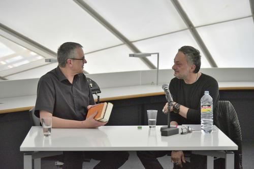 Der Künstler Axel Malik überreichte Feridun Zaimoglu zwei mit Schriftzeichen überzogene Bücher.