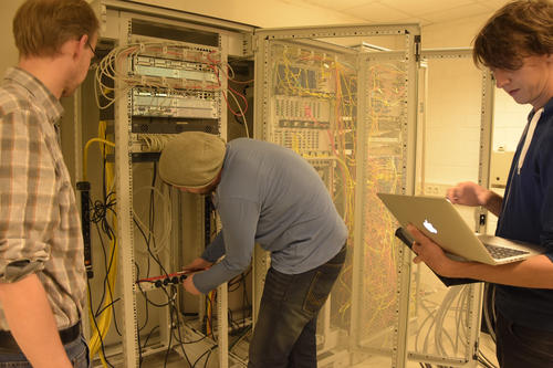 Mitarbeiter der ZEDAT bereiten einen Hauptverteiler des Datennetzes in der Silberlaube auf die Versorgung durch ein Notstromaggregat vor. Von links nach rechts: Harald Scheelken, Marc-Vincent Schremmer, Michael Mundry.