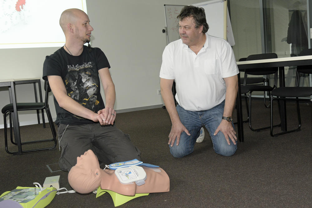 Lutz Thormann (re.) von der Dienststelle Arbeitssicherheit erklärt einem Teilnehmer die Benutzung des Automatischen Externen Defibrillators.