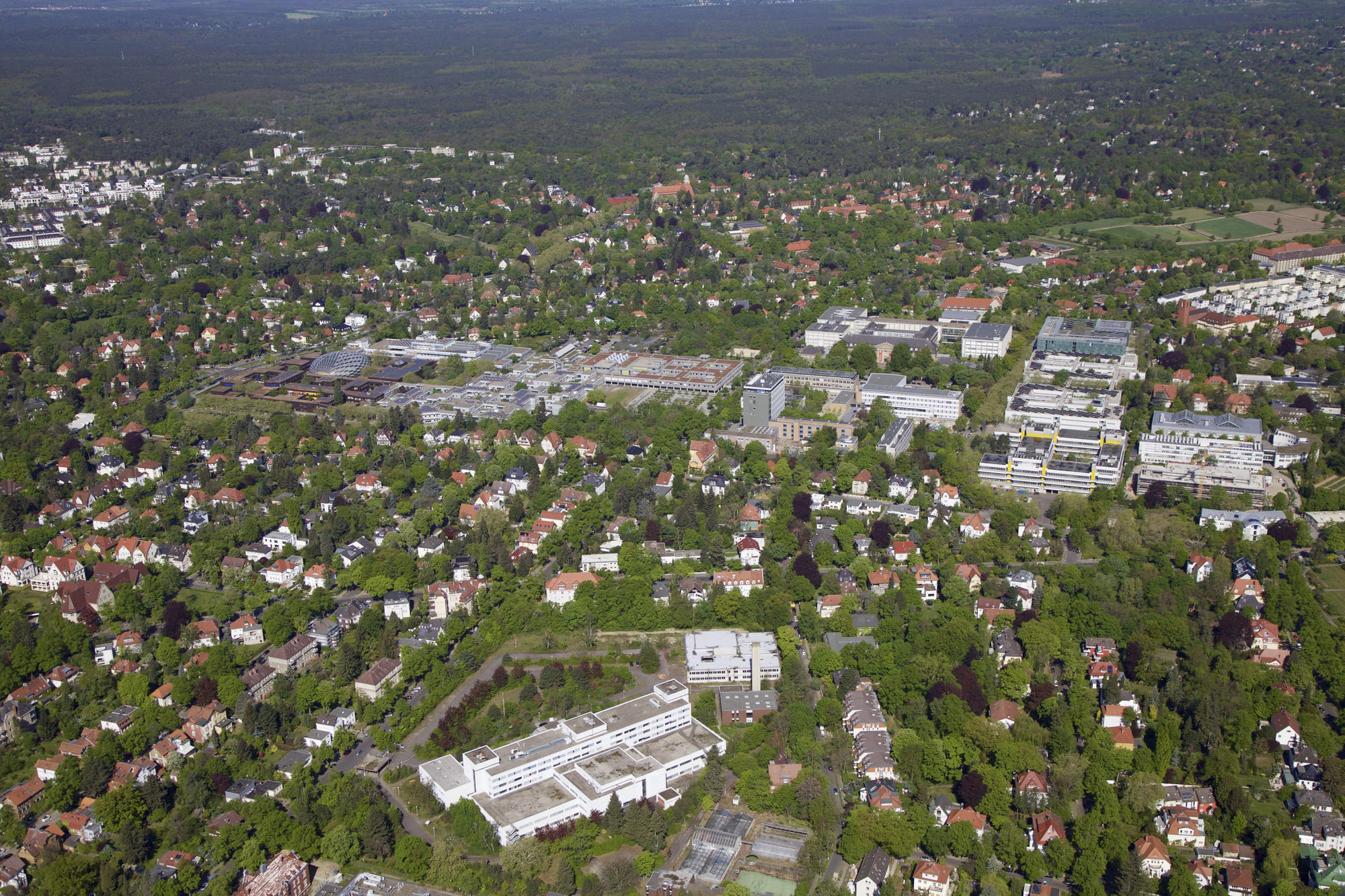 Der Campus Dahlem der Freien Universität und im Vordergrund das FUBIC (weißer Komplex). Das Luftbild wurde im April 2019 aufgenommen.