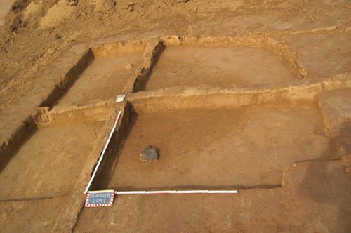 Ausgrabung eines präshistorischen Fundplatzes unterhalb des heutigen Pflughorizontes. Deutlich zu erkennen sind die dunkleren Sedimente in der Bildmitte, die vermutlich eine eisenzeitliche Abfallgrube mit zahlreichen Befunden darstellen.