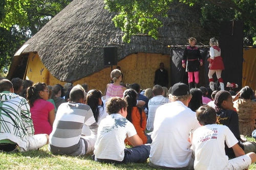 Eine Performance im Stadtpark Harare Gardens in Zimbabwe während des Harare Festival of the Arts (HIFA) im April 2009. Das Setting – Performance im Park, Zuschauer auf der Wiese – ist typisch für Angewandtes Theater in Afrika.