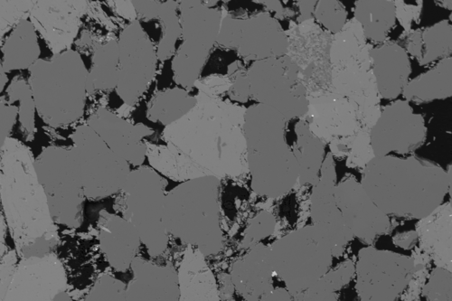 A scanning electron microscope image of sandstone. The pore space is shown in black.