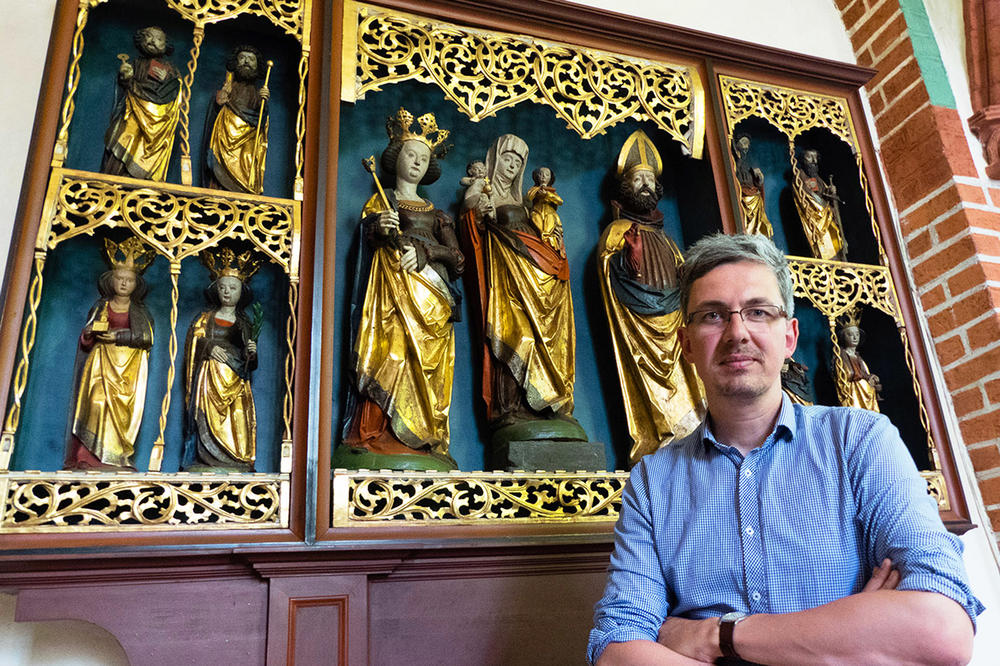 Justin Kroesen vor dem Altarschrein (ausgehendes 15. Jahrhundert) der Dahlemer St.-Annen-Kirche.