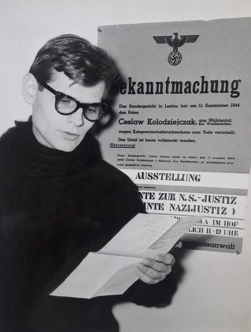 Reinhard Strecker vor dem Plakat von der von ihm initiierten Ausstellung.