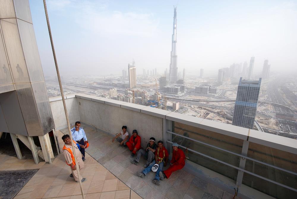 Das andere Dubai: Bei bis zu 40 Grad schuften Gastarbeiter auf den Großbaustellen. Im Hintergrund das höchste Gebäude der Welt, der Burj Khalifa.