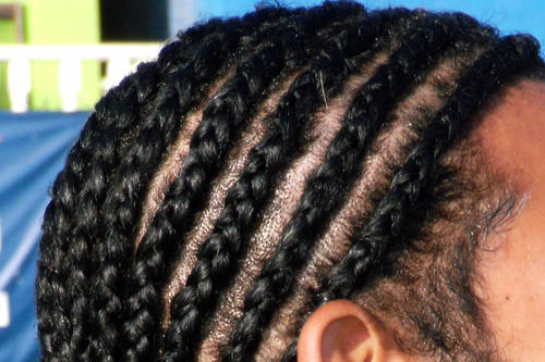 Die sogenannten Cornrows sind afrikanischen Ursprungs. Das Haar wird eng an der Kopfhaut geflochten. "Cornrows" gelten als typisches Beispiel für Gangsta Rap-Frisuren der 90er Jahre.