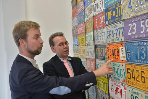 Uli Finkenbusch (li.) erklärt Irwin Collier, Leiter des John-F.-Kennedy-Instituts und Wirtschaftsprofessor, die Bedeutung eines Schildes aus dem US-Bundesstaat Iowa. "Wir sind über das Geschenk hocherfreut", sagt Collier.
