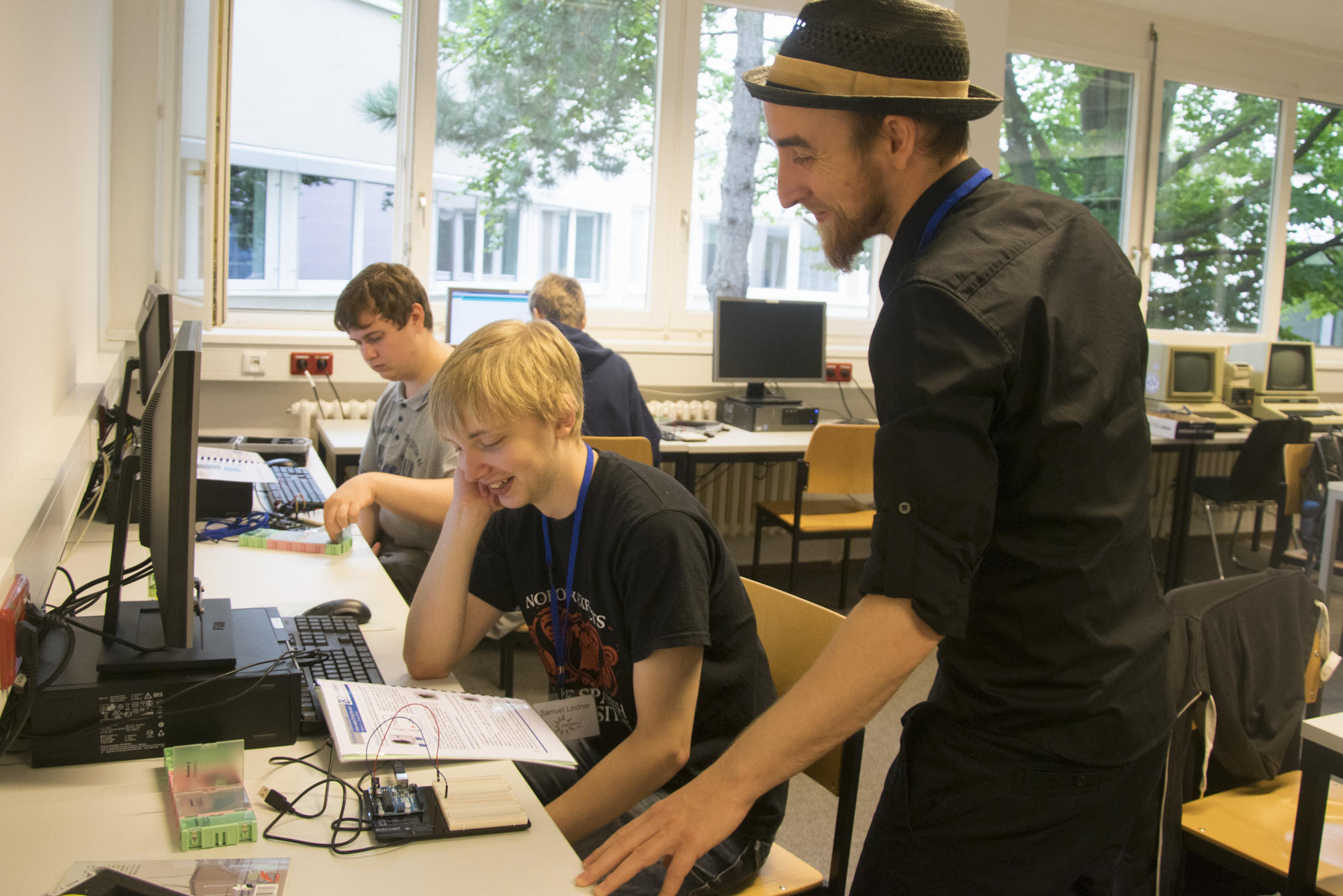 Teilnehmer des Workshops "Informatik enlightened: Was Autos, Blumen, Menschen und Solarzellen verbindet". Student Toni Draßdo erläutert einem Schüler die Funktionsweise eines Arduino-Microcontrollers.