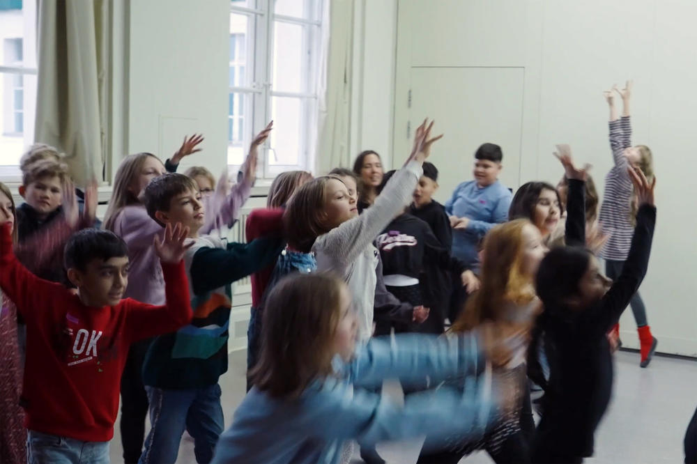 Kinder der Erika-Mann-Grundschule entdecken tänzerisch, wie Mikroplastik durch die Welt wandert: Es reist von Flüssen ins Meer, durch die Luft in den Boden, aus der Nahrung bis in unser Blut.