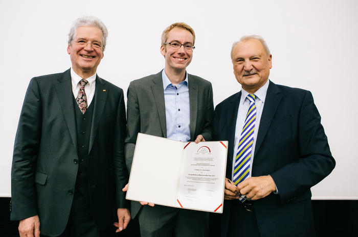 Strahlender Preisträger. Experimentalphysiker Professor Claus Ropers (Mitte) nahm die Auszeichnung aus den Händen der beiden Stiftungsvorstände entgegen: Dr.-Ing. Lothar Wilhelmy (links) und Peter Lange von der Otto-Klung-Stiftung (rechts).