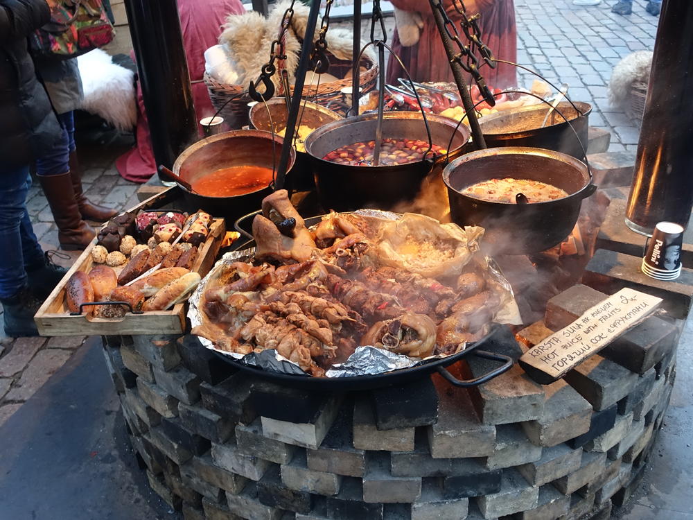 Auf dem Weihnachtsmarkt in Riga werden Fleisch und Suppe auf mittelalterliche Art zubereitet.