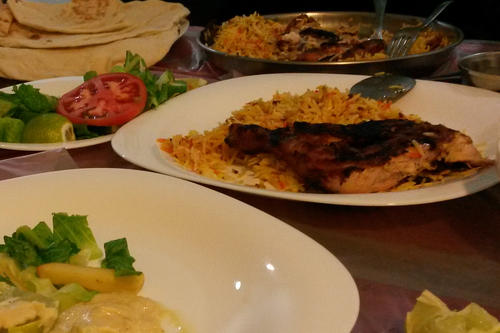Hühnchen mit Reis und Salat, Kartoffeln und Humus und natürlich Brot. Das Bild zeigt typische omanische Speisen. Beim traditionellen Familienessen, bei dem Salome Shuwa gekostet hat, hat sie aus Rücksicht aufs Fotografieren verzichtet.