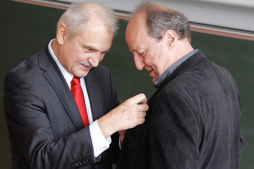Kanzler Peter Lange steckt die Ehrennadel an. Deuflhard habe die Anfang der 1980er noch junge Fachrichtung Scientific Computing an der Freien Universität konsequent vorangetrieben.