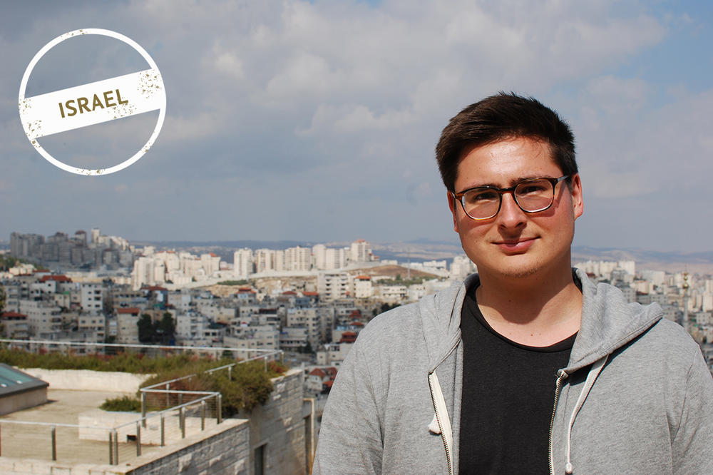 Julian Jestadt on a lookout point near the Rothberg International School on Mount Scopus. The wall separating the West Bank from Israel is in the background on the left.