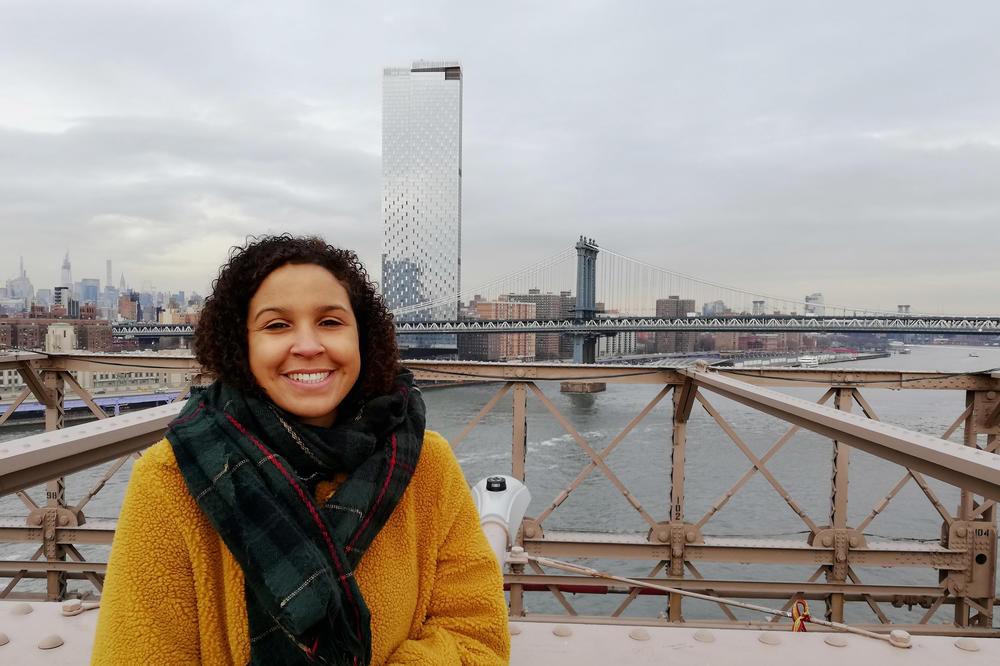 Madeline Thomas on the Brooklyn Bridge over the Hudson River in New York
