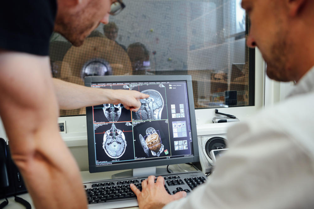 Two researchers from the Center for Cognitive Neuroscience Berlin analyze brain images in the MRI control room. They use images like this as measurements to study the structure of the brain.