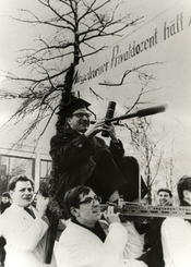 Student protests in 1966: A young postdoc protests ironically by using a telescope to search the surrounding area for a research position.