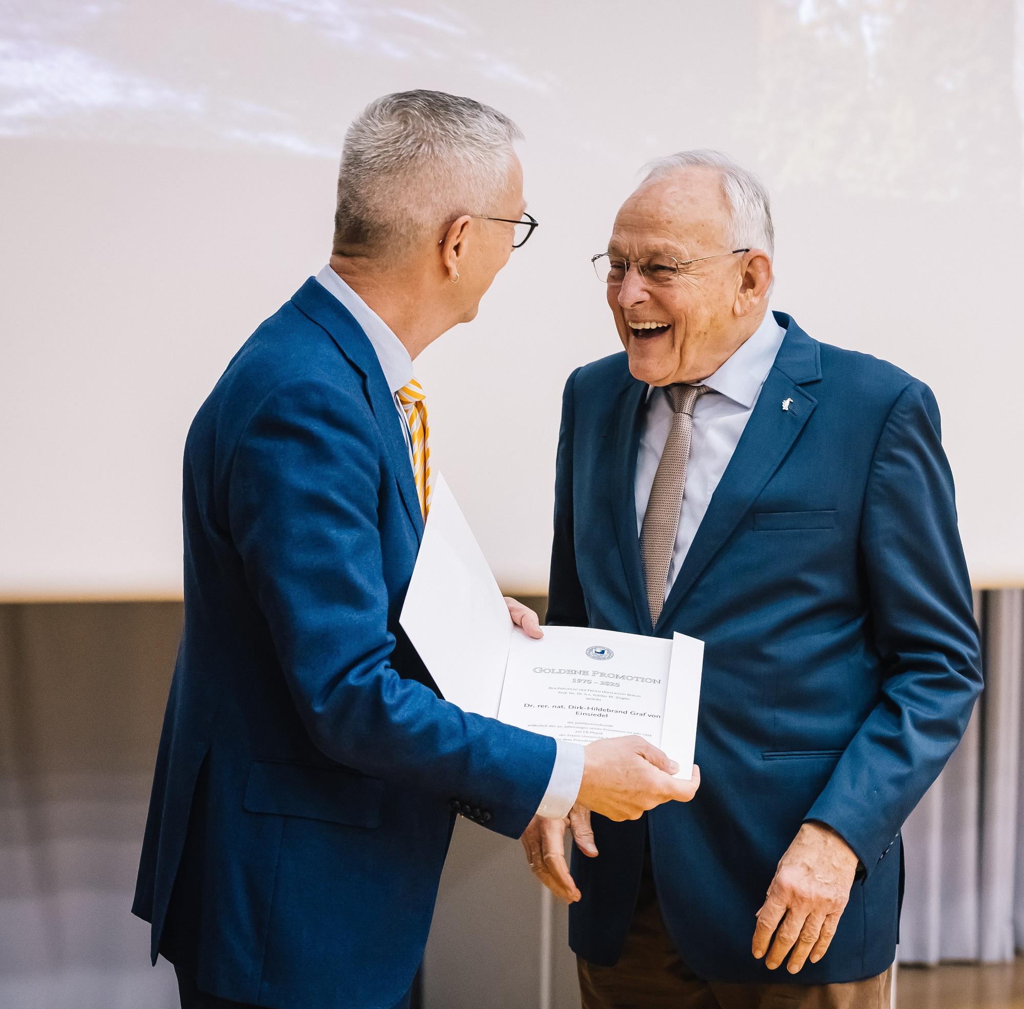 President of the university Professor Günter M. Ziegler handing Dr. von Einsiedel his Golden Doctoral Jubilee certificate.