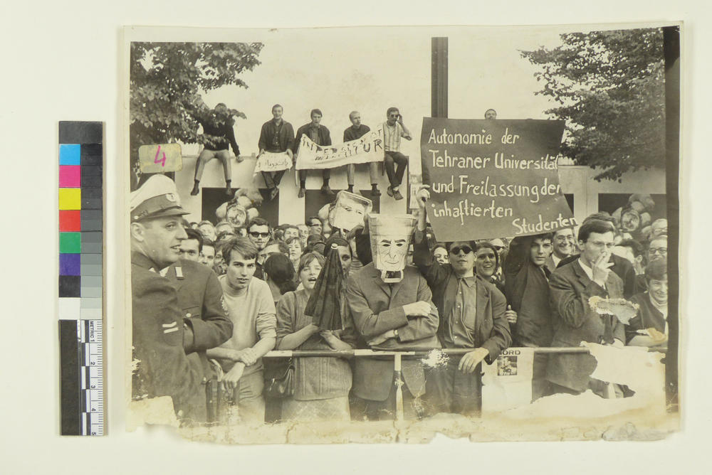 With posters and paper bags: Protests against the visit of the Shah couple in 1967 opposite the Deutsche Oper in Berlin-Charlottenburg.