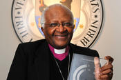 Bishop Desmond Tutu is shown holding the Freedom Award.
