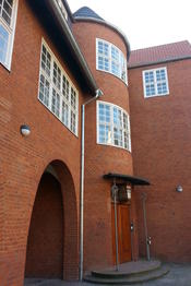 The façade of the International House with a massive tower and parabolic arcades.