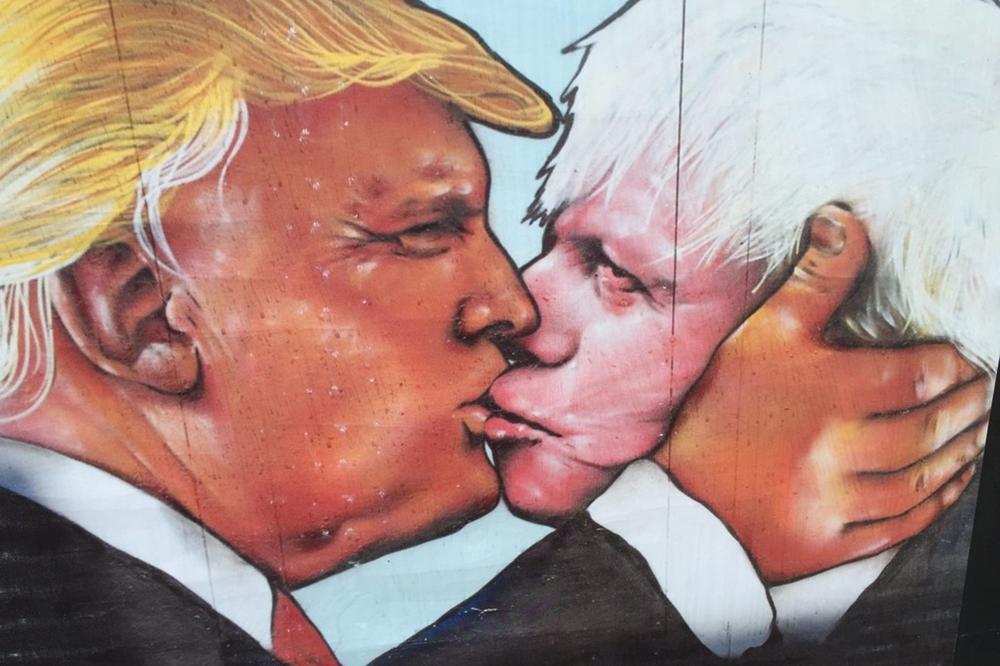 Das satirische Wandbild zeigt Donald Trump und Boris Johnson in überzeichneter Pose und veranschaulicht die emotionale Inszenierung politischer Nähe, wie sie im Rahmen der Veranstaltung thematisiert wird.