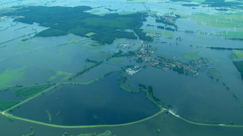 Wass im Überfluss: Der Deich bei Fischbeck in Sachsen-Anhalt ist gebrochen, Wassermassen fließen ins Hinterland, Gischt schäumt (im Bild unten rechts).
