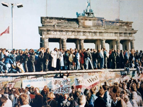 Den Schrecken verloren: Einen Tag nach der Grenzöffnung am 9. November 1989 ist die Berliner Mauer am Brandenburger Tor ein beliebter Ort für ausgelassenes und friedliches Feiern. Für Ost- und Westberliner gleichermaßen.