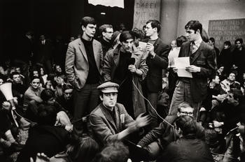 Issues regarding university policy are discussed at a sit-in on April 19th and 20th, 1967, in the lobby of the Henry Ford Building. Knut Nevermann is standing at the left of Rudi Dutschke.