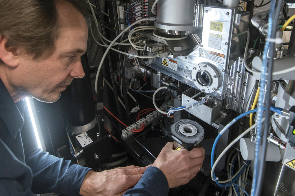 Christoph Böttcher, wissenschaftlicher Leiter des Forschungszentrums für Elektronenmikroskopie am Institut für Chemie und Biochemie, überführt in einem Gefäß ein schockgefrorenes Präparat in das Hochvakuum des Elektronenmikroskops.