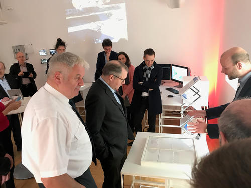 Safety and security researcher Roman Peperhove (right) explains to Albrecht Broemme (THW president, left) and Bundestag members Michael Kuffer (CSU, center) and Benjamin Strasser (FDP, background) how to find an escape route out of a maze.