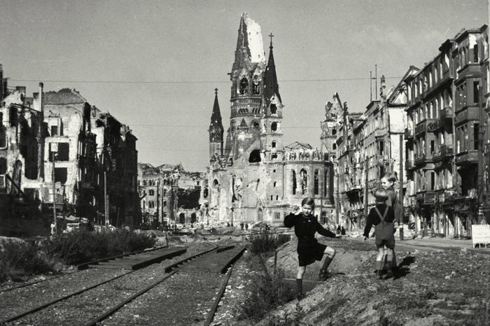 Mahnmal. Vor der Ruine der Kaiser-Wilhelm-Gedächtniskirche spielen Kinder im Nachkriegs-Berlin auf der zerstörten Tauentzienstraße.