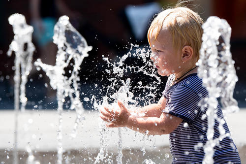 Erfrischung willkommen. Ein Zweijähriger planscht im Juli 2019 bei Temperaturen nahe 40 Grad Celsius in einem städtischen Brunnen. In Innenstädten machen sich Hitzewellen und Rekordtemperaturen besonders stark bemerkbar.