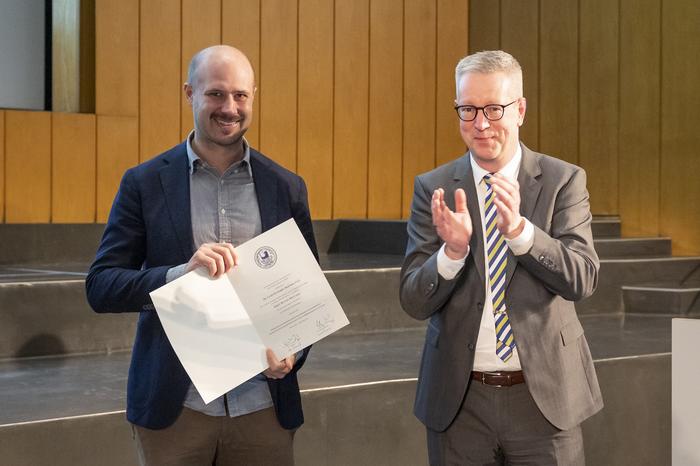 Dr. med. vet. Christof Bertram, PhD, erhält die Urkunde von Präsident Prof. Dr. Günter M. Ziegler. (v.l.n.r.)