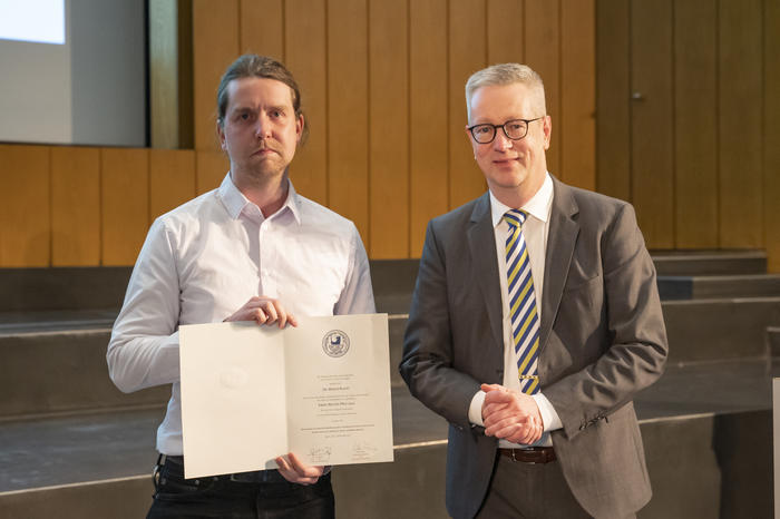 Dr. rer. nat. Merlin Kleoff erhält die Urkunde von Präsident Prof. Dr. Günter M. Ziegler (v.l.n.r.).